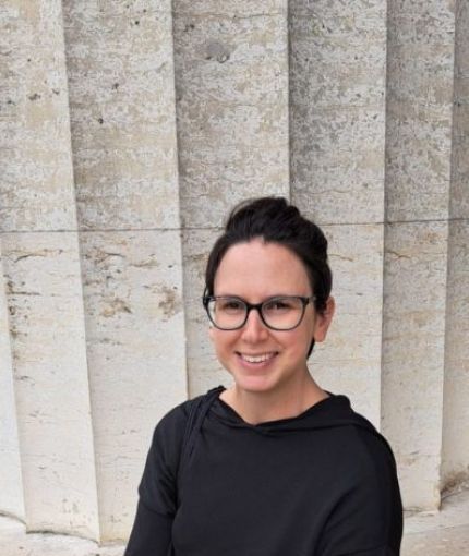 Woman sitting in front of a column.