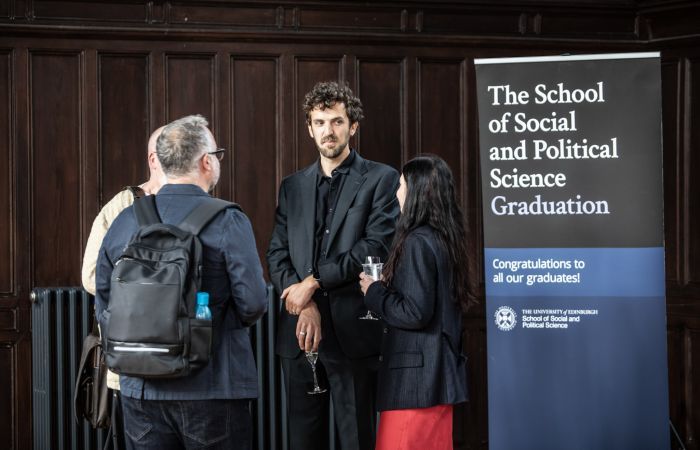 Students chatting next to SPS Graduations banner