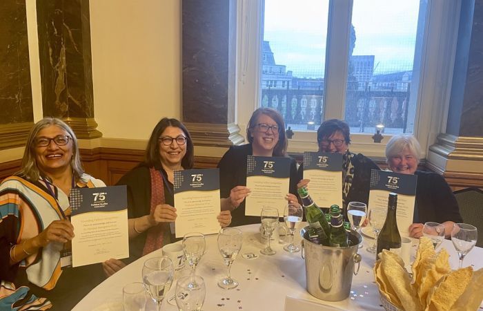 Photo of five women, all PSA Founding Fellows, holding their certificates and smiling at the camera