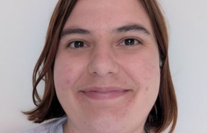 I am smiling at the camera, forward facing, in front of a white background.